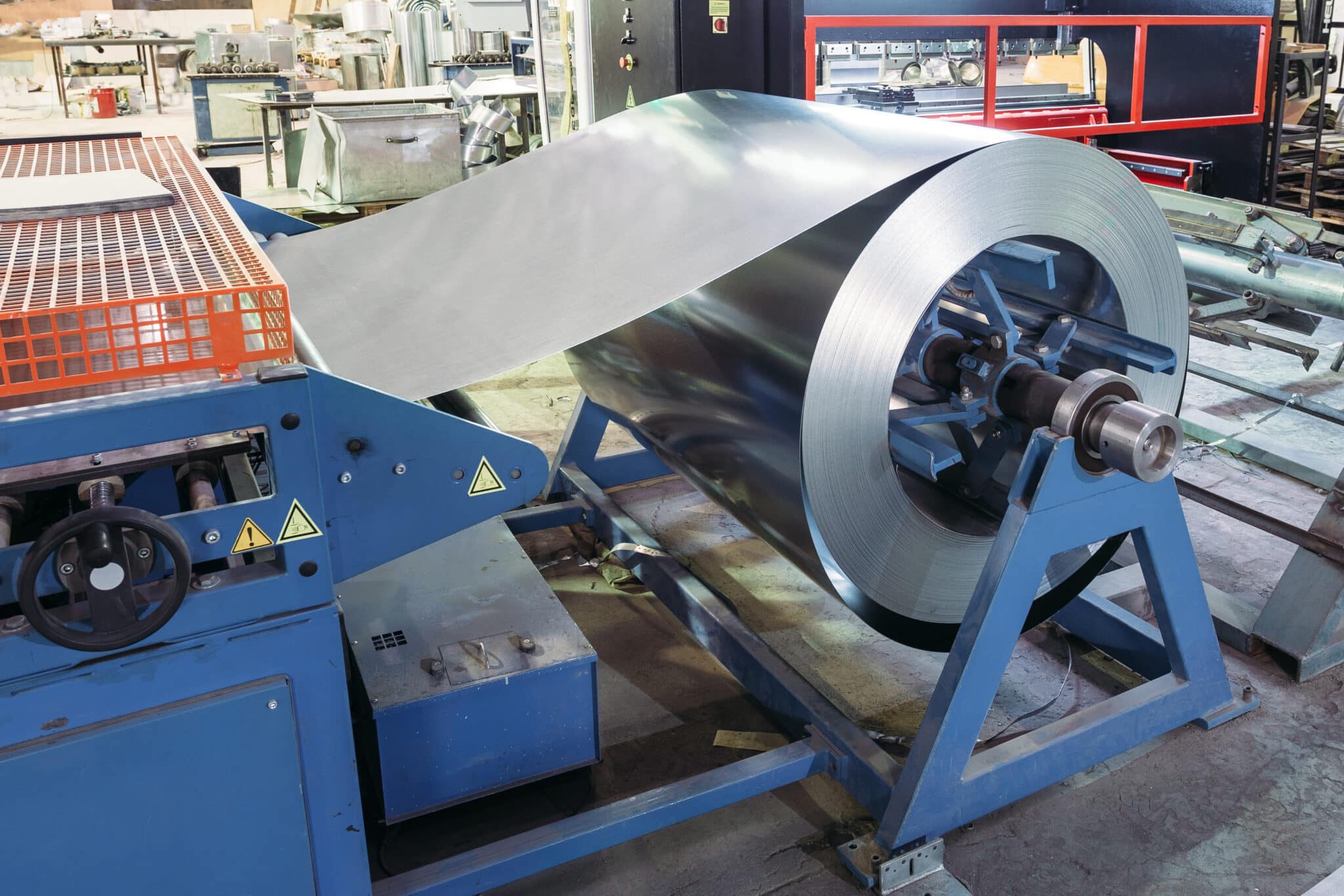 Roll of galvanized steel sheet for manufacturing metal pipes and tubes in the factory.